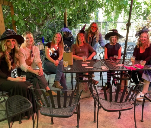 a group of ladies dressed up for Halloween enjoying wine on Milliaire's patio